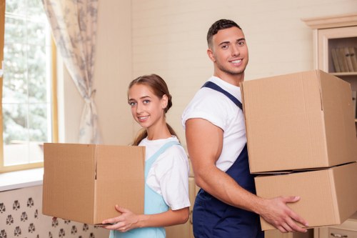 Movers carrying boxes and furniture during a local removal service